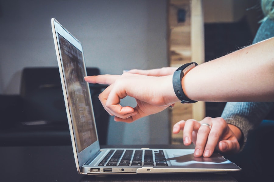 A person managing customer communication from a laptop and phone.